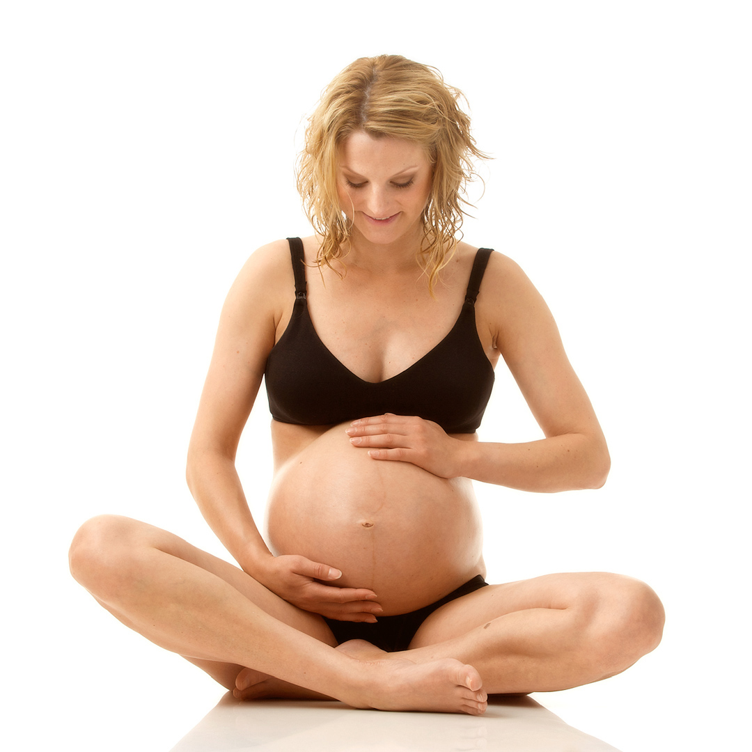 Gravid kvinna sitter på golv